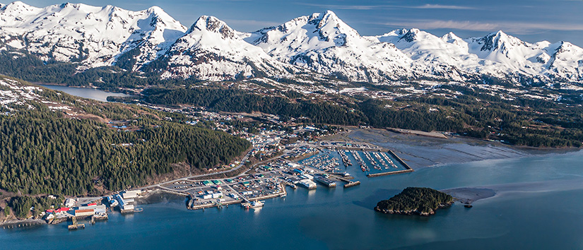 communities-istock-1282751408 Aerial view of Cordova, Alaska shoreline with mountain range in background.