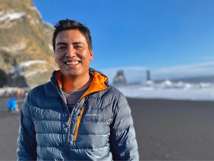 A man smiling on a beach.