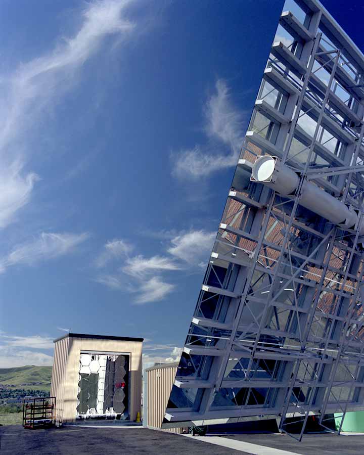 201909-hfsf The high-flux solar furnace concave mirrors and heliostat in front of a blue sky