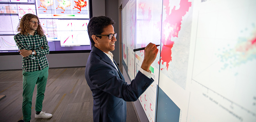 data-integration-analysis-71803 Photo of two researchers looking at large computer display and writing on it