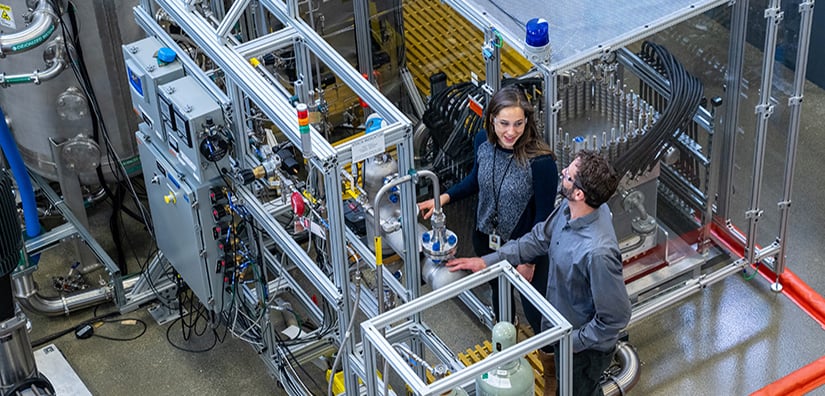 user-access-74281 Two researchers looking at mechanical equipment in the ESIF.