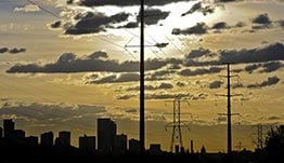 grid-integration-modeling-19890-cap Transmission lines near a city skyline.
