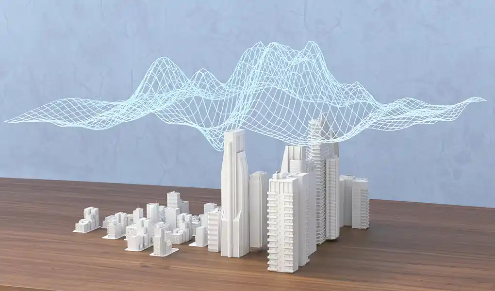 Building replicas on a table with a data web hovering above them.