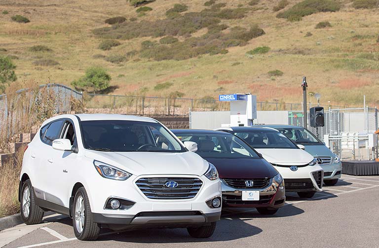 h2_facilities_landing_768x502_34855 Photo of four vehicles lined up side by side next to a hydrogen fueling station.
