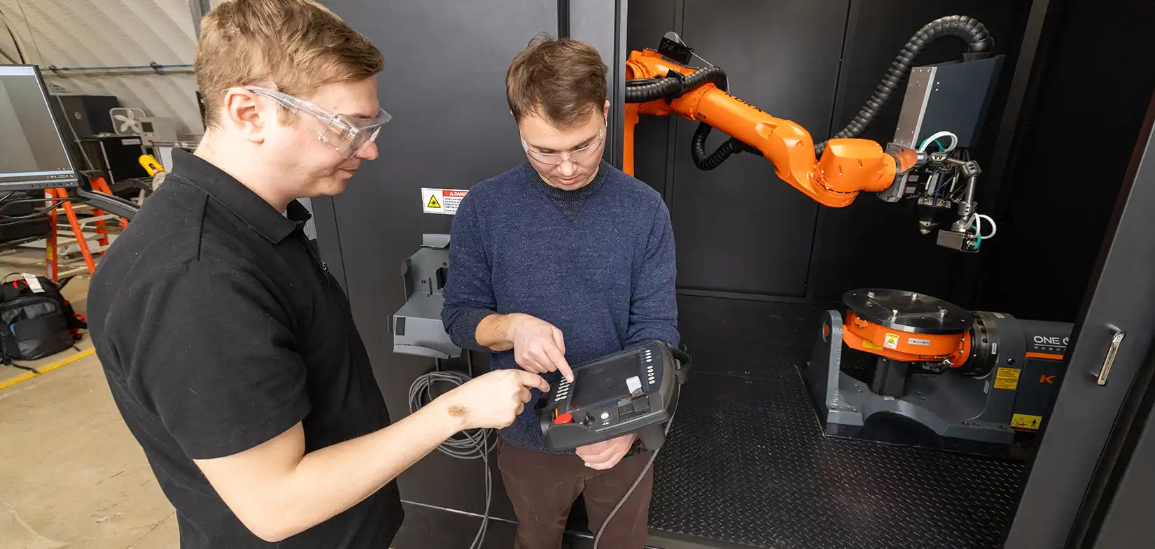 work-with-us-96029-hero Two researchers looking at a handheld controller.