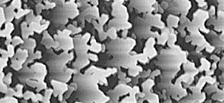 hp_interfacial_surface Image of irregular-outlined, light-colored shapes on a dark background. Represents a tapping-mode atomic force microscope image of gallium phosphide on silicon.