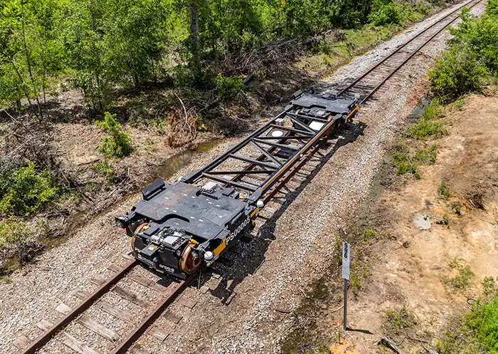 An unloaded automated rail vehicle propels itself down rail tracks in the state of Georgia