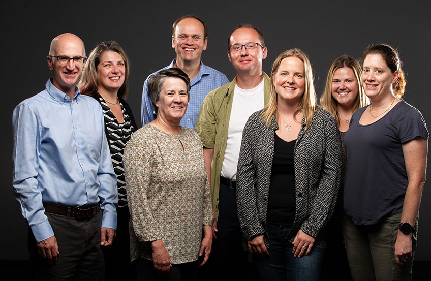 A group of men and women pose for a portrait.