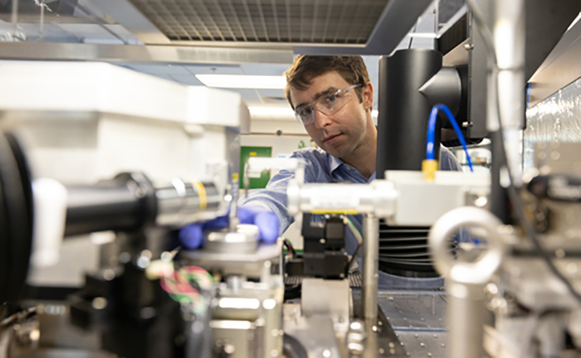 A researcher working with a machine.