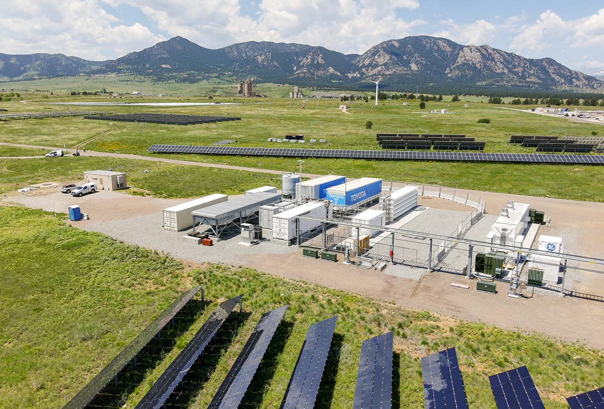 20250707-beyond-flights-airports-could-bolster-grid-security-and-adaptability-nrel-flatirons-campus-82063 Aerial view of a research campus showing solar panel arrays and other facilities with mountains in the background