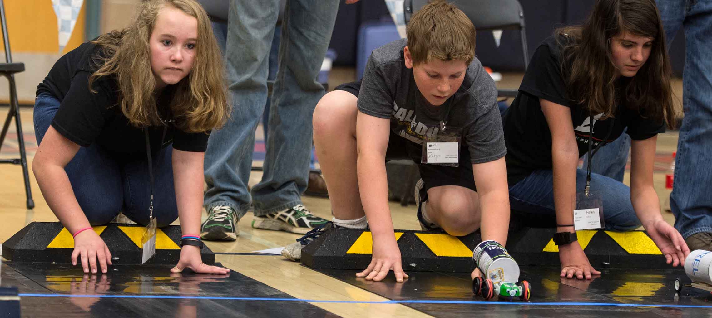 Photo of a group of students at the starting line for a race between battery-powered cars.