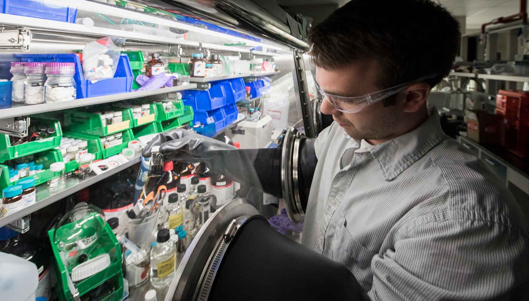 Photo shows a man with his arms inside a glove box.