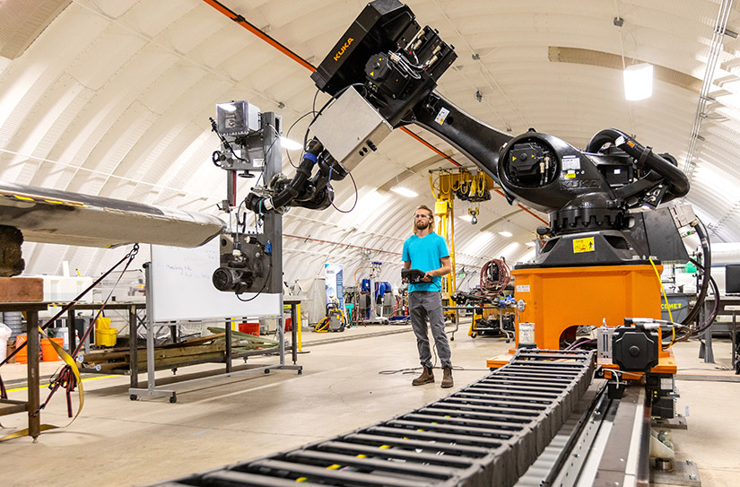 A man stands next to a piece of machinery.
