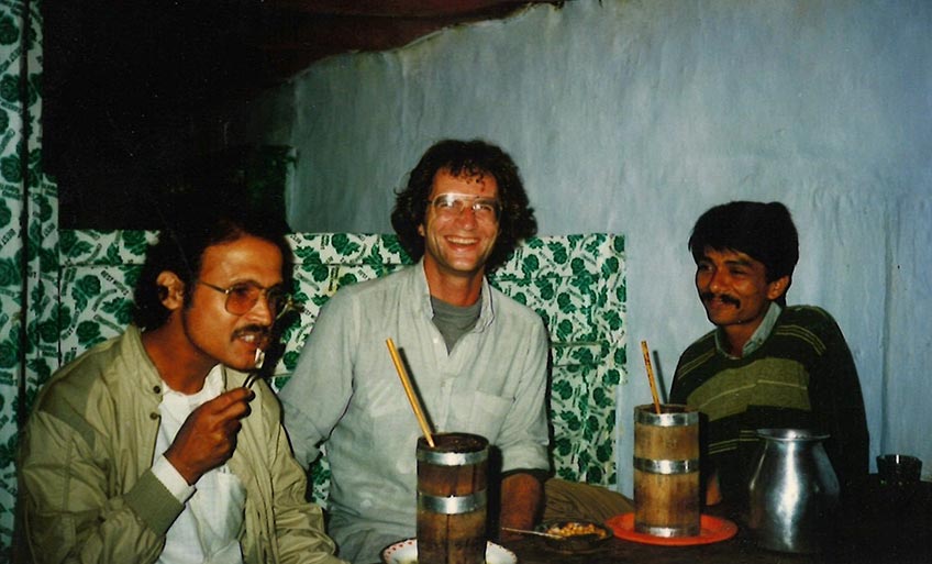 Three men sitting at a table smiling.