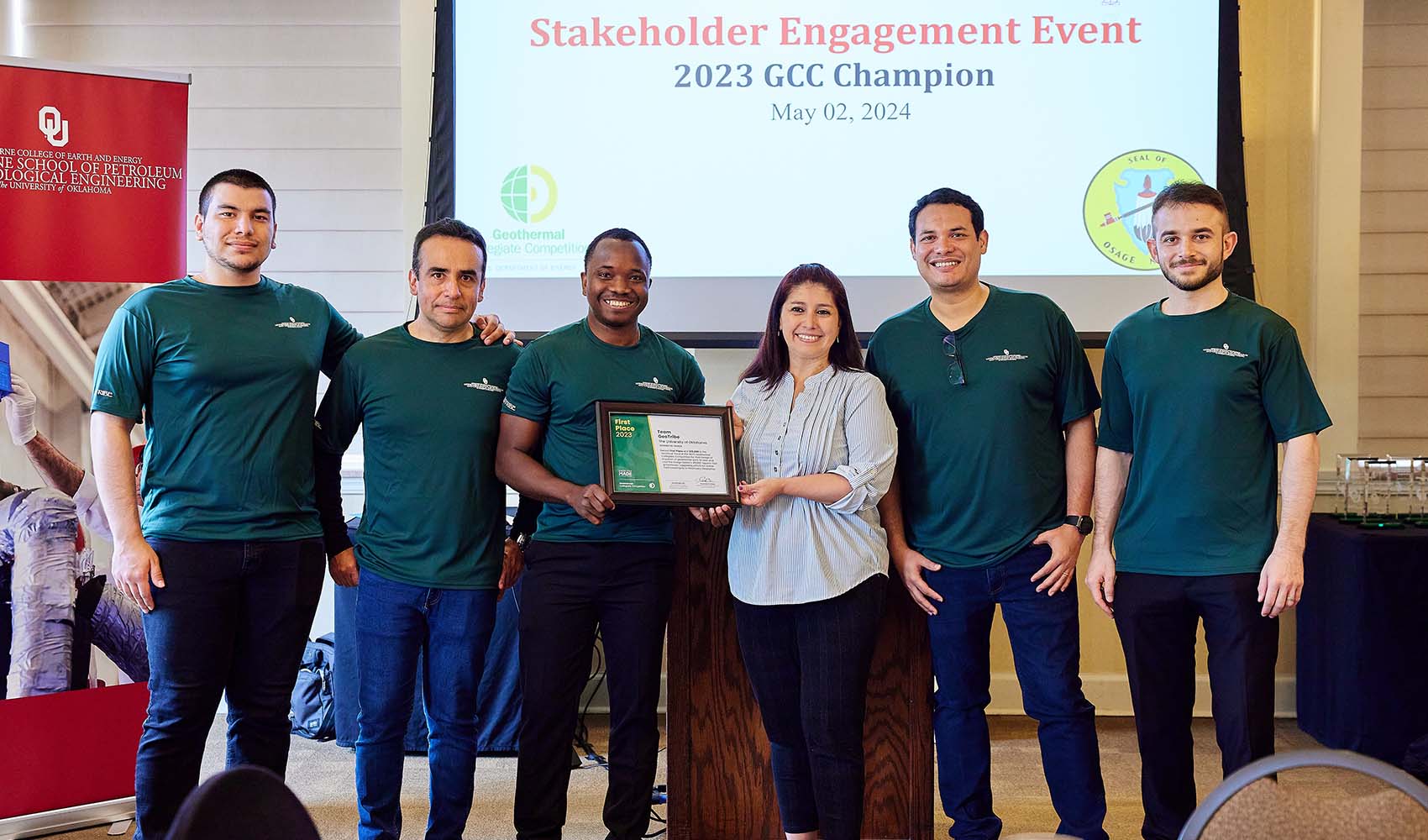 Six individuals pose with a certificate.