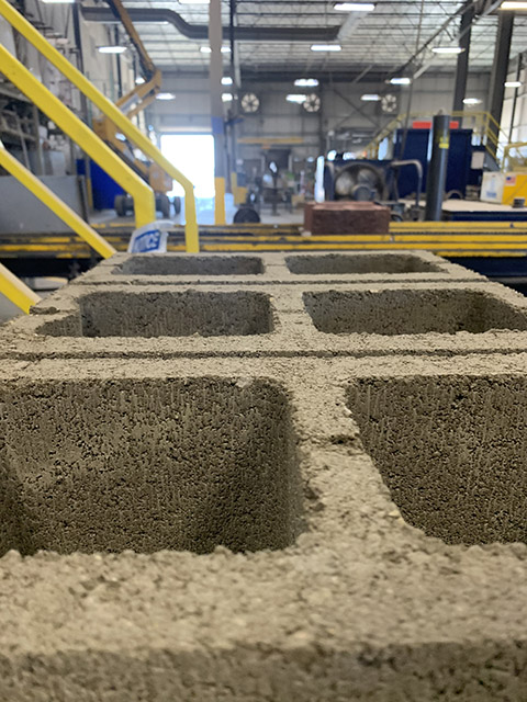 Cinder blocks lined up in a manufacturing plant after creation.