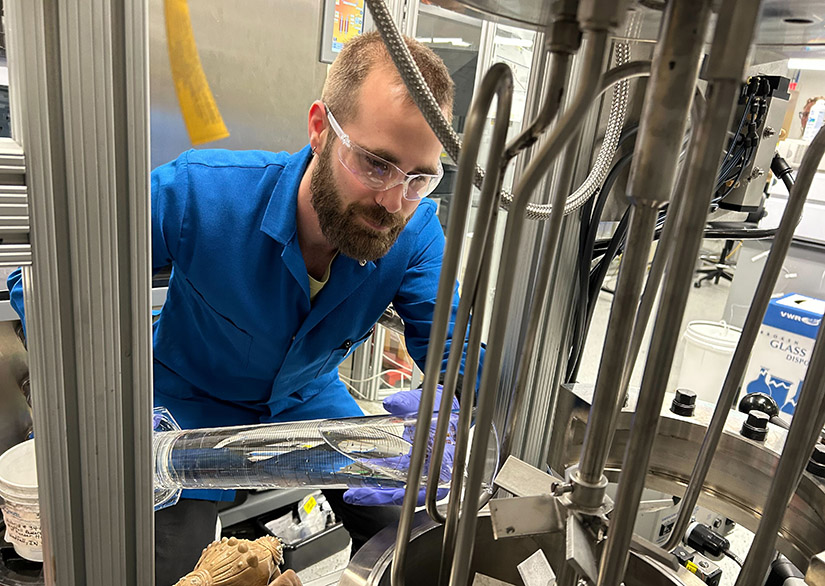 20250312-with-a-technology-license-from-mit-nrel-comstock-fuels-produce-jet-fuel-from-lignin-4231 A researcher pours a liquid into a machine in a lab.