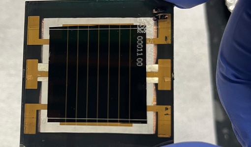 A hand holds a perovskite minimodule.