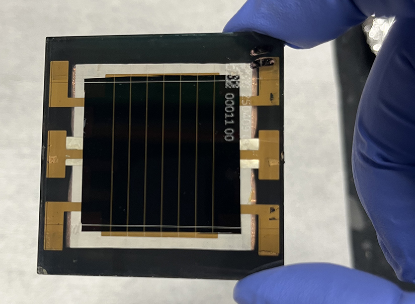 20250630-collaboration-between-nrel-cubicpv-pushes-perovskite-minimodule-performance-new-heights A hand holds a perovskite minimodule.