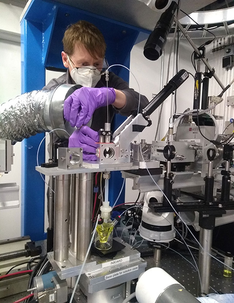 20250702-collaboration-reveals-how-light-unlocks-chemistry-of-nickel-catalyst A researcher wearing gloves prepares solutions in a lab.