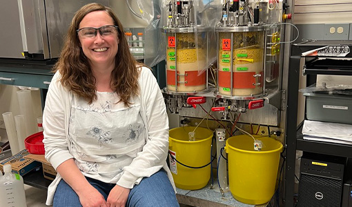 A person sitting in a chair in a lab, smiling.