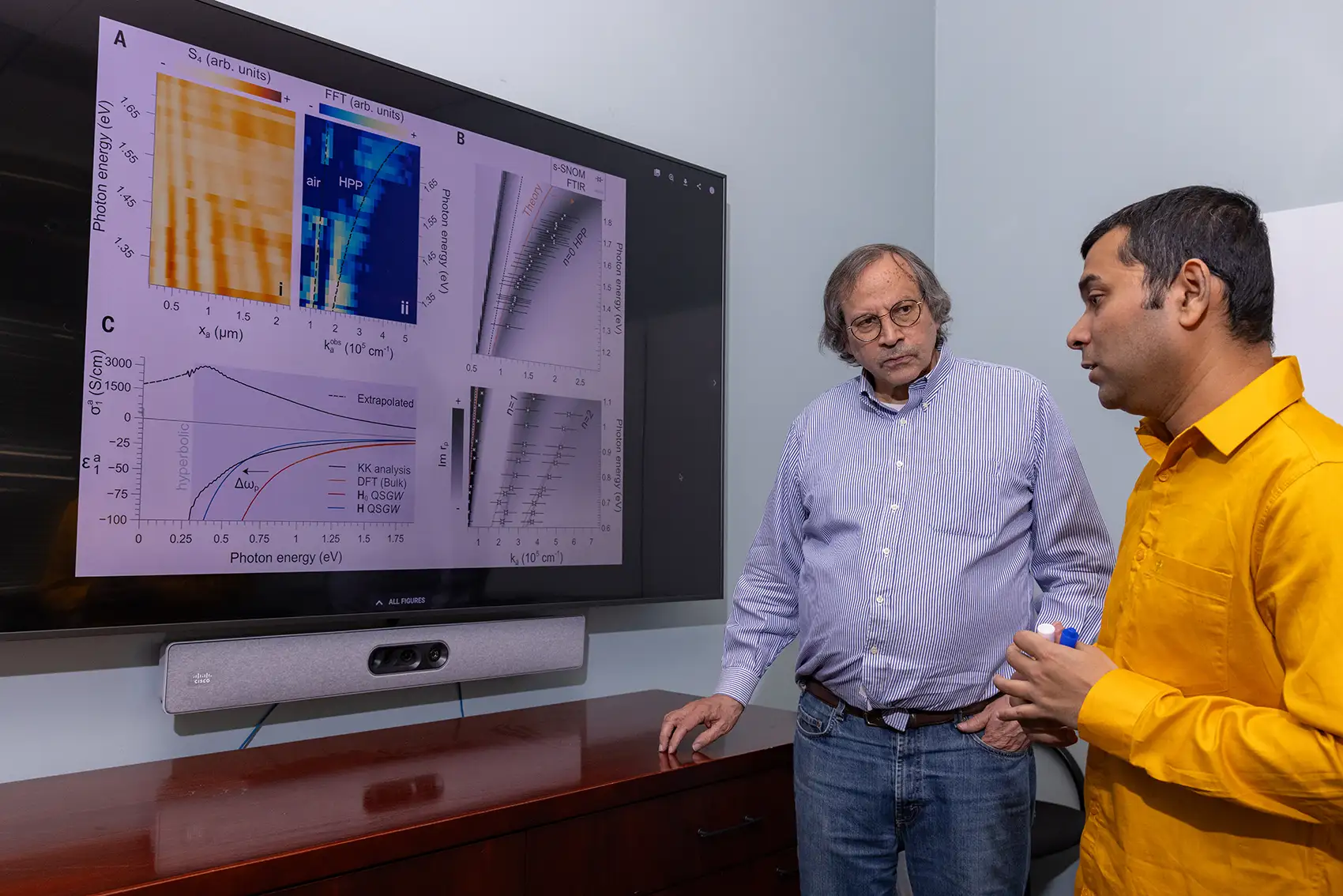20250805-researchers-surf-magnon-wave-control-particles-next-gen-electronics-99395 Two people look at a screen with graphs on it.