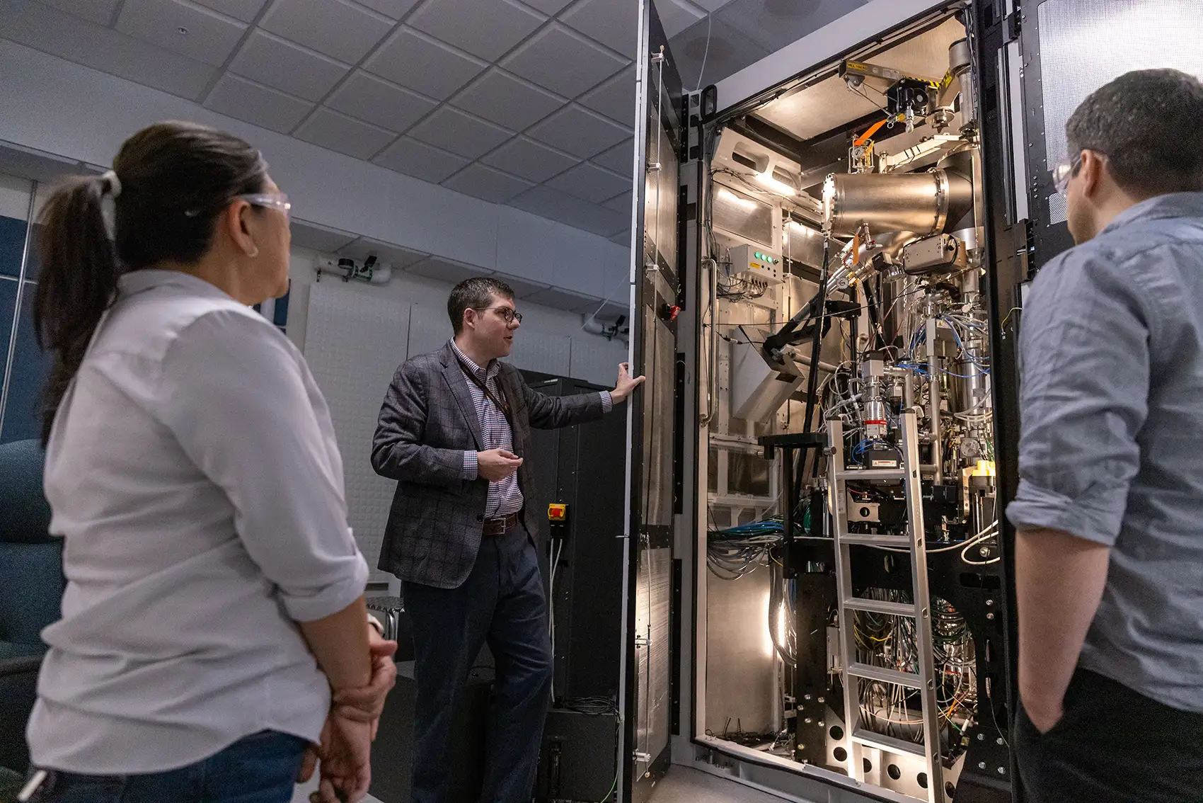 20250814-ai-could-help-bridge-valley-of-death-for-new-materials-99315 Researchers view an autonomous electron microscope in the basement of the Solar Energy Research Facility at NREL.
