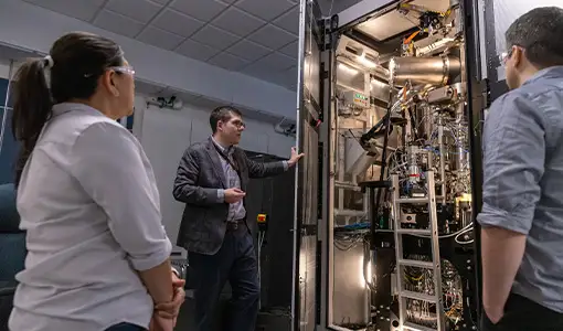 Researchers view an autonomous electron microscope in the basement of the Solar Energy Research Facility at NREL.