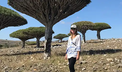 Kristi Moriarty stands in front of funnel-shaped trees.