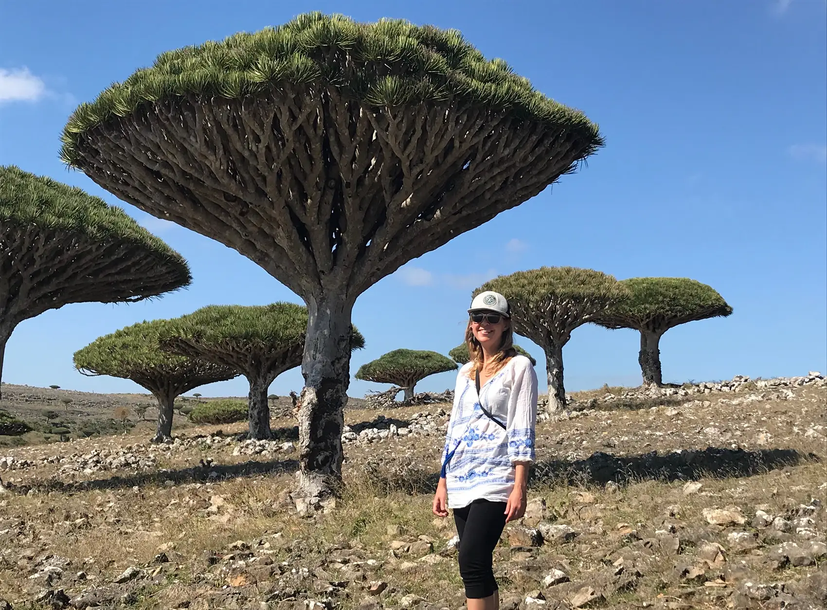 Kristi Moriarty stands in front of funnel-shaped trees.