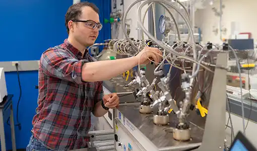 A scientist works with a reactor.