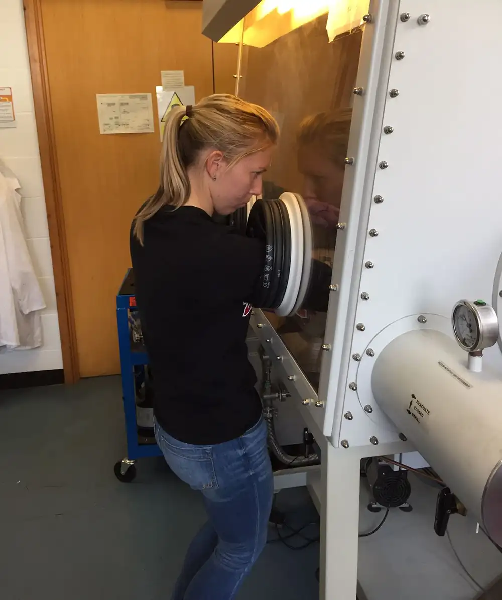 20251210-she-wanted-to-write-fantasy-now-she-is-rewriting-recycling-lab-vertical A side view of Taylor standing next to and using lab equipment.