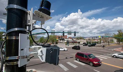 Continue reading about Scientific equipment attached to a pole near a traffic intersection.