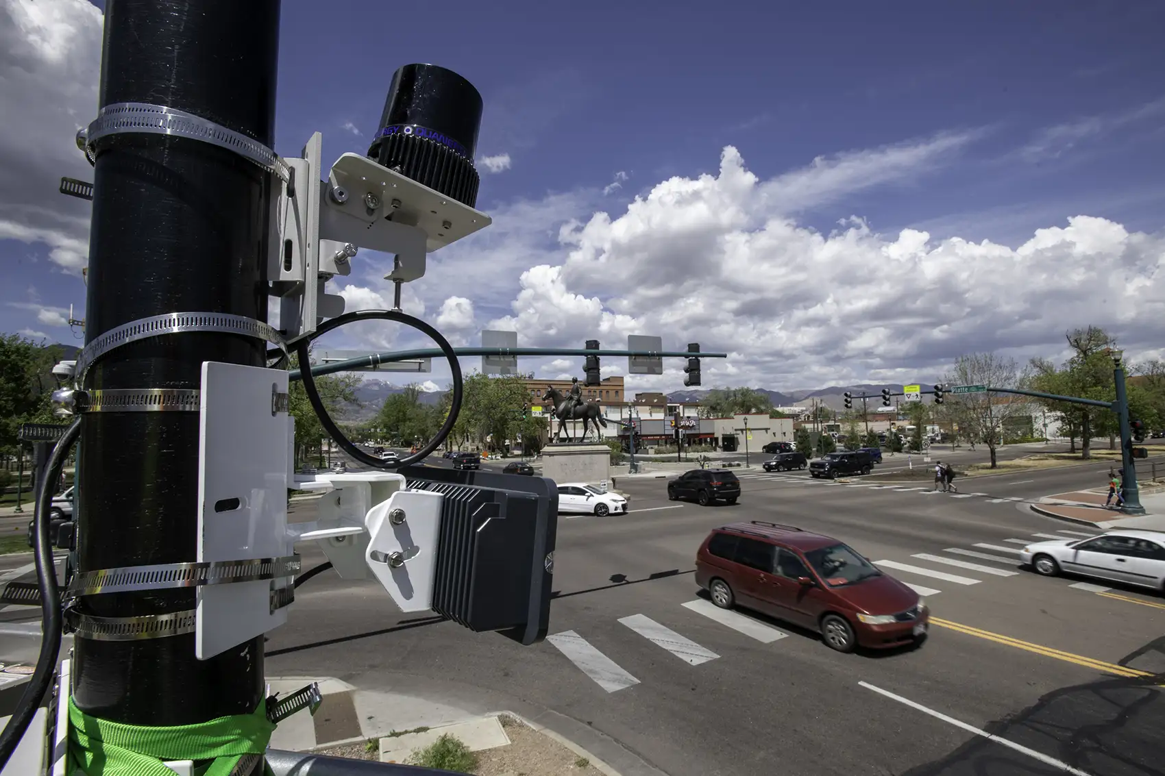 Scientific equipment attached to a pole near a traffic intersection.