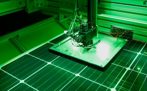 hp-spectral-response-testbed A solar module sits underneath a square shade that covers several cells around the measured cell. A bundle of black fibers runs from LEDs to the center of this shade to measure the desired cell.