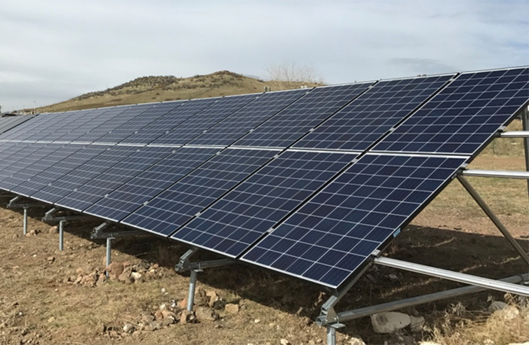 pvlifetime-qcells Photo of blue solar panels mounted on the ground.