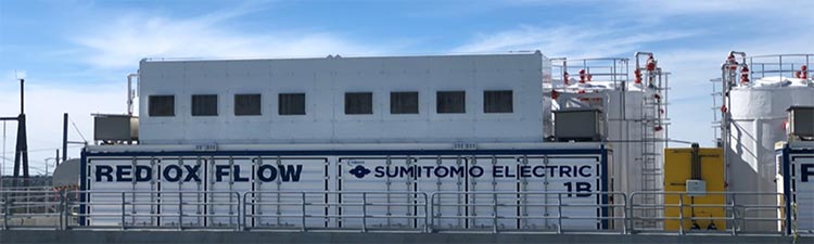 project-sumitomo Large battery enclosures and equipment inside a gated structure.