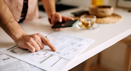 A man using a calculator on the phone to calculate expenses