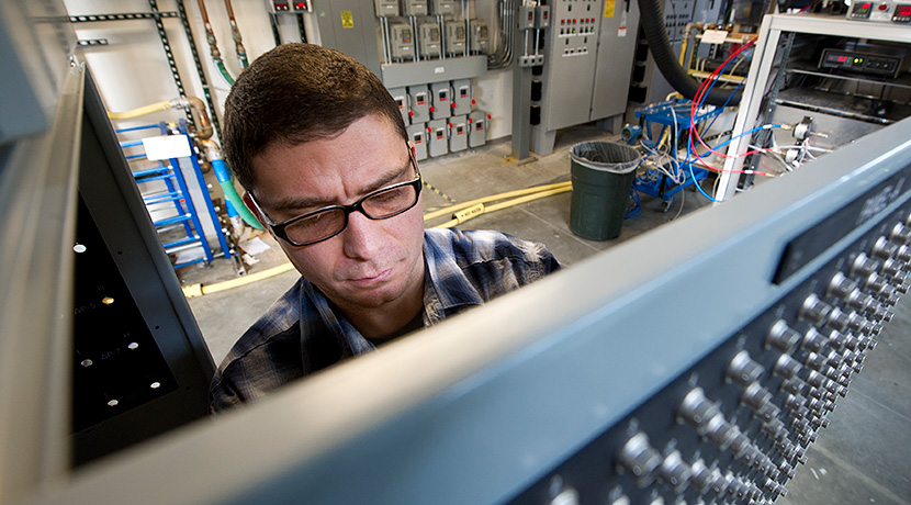 Photo of a person operating a data acquisition panel in a laboratory