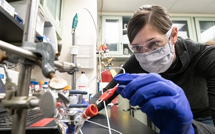 63736-block Researcher assembles a 3-electrode electrochemical microcell.