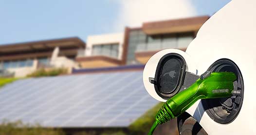 Close up view of Electric Car charging with solar panels in the background*