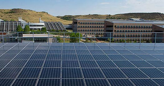 solar PV array on a rooftop of a building with a view of many buildings in the background.