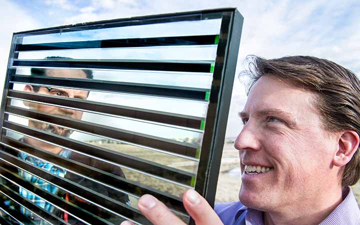 research-areas-35468 Engineers examine a demonstration model of a Smart Glass product outside.