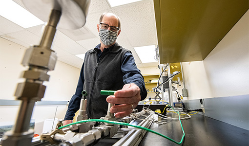 62471 A researcher adjusting lab equipment.