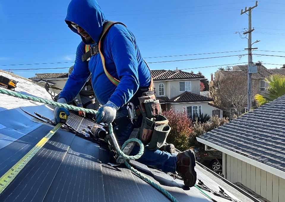 gaf-energy-flt Installer measuring solar shingles on a roof