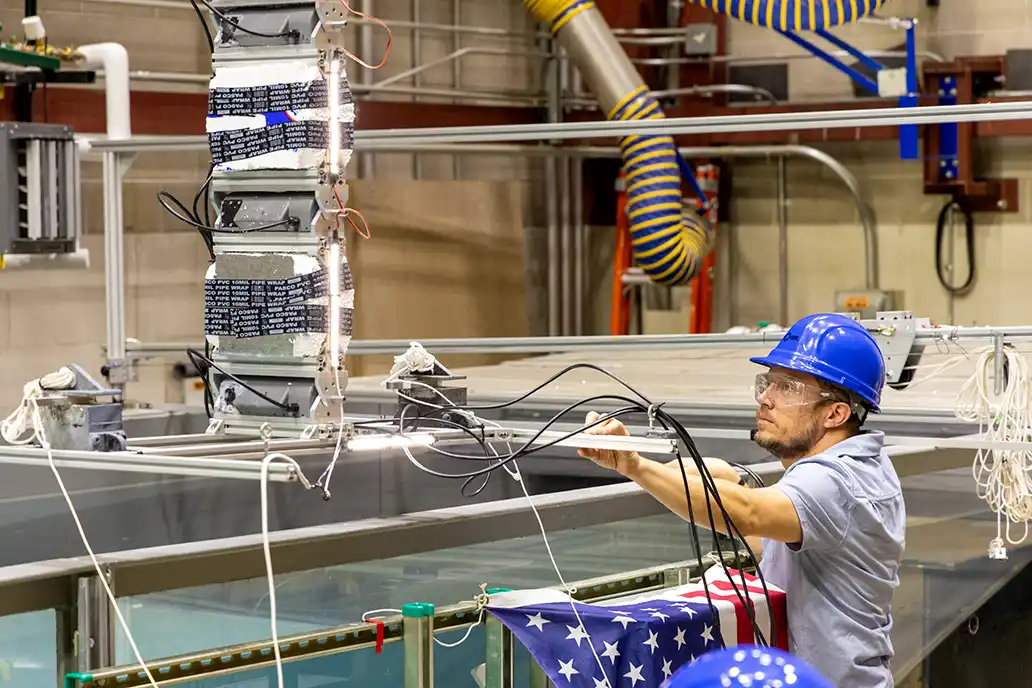 202507-newsletter-wave-tank-9386 An NREL researcher validating marine energy devices in a wave tank.