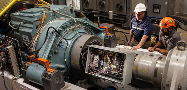 marine-energy-podcast Two people working on marine energy device inside laboratory