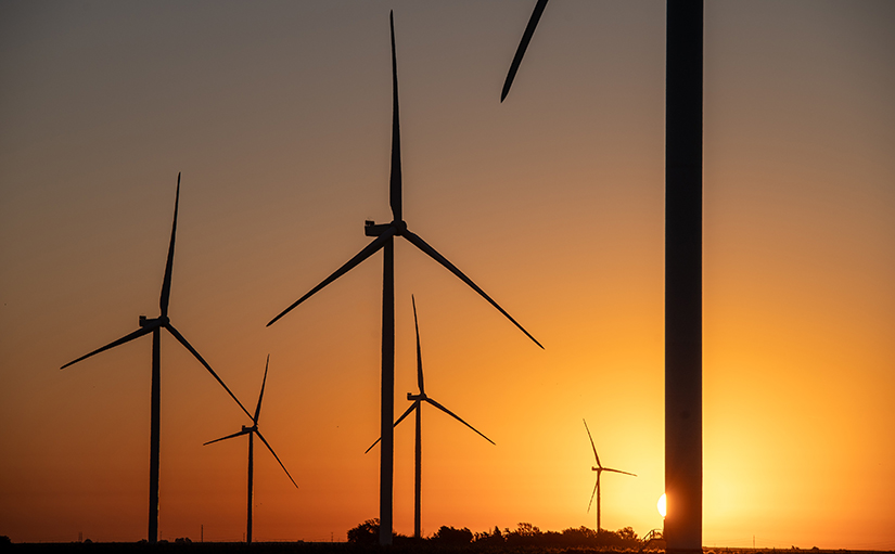 20240528-newsletter-artificial-intelligence A sunrise behind a wind farm.