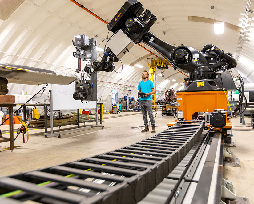 20240528-newsletter-robots-could-boost Man controls large robotic arm