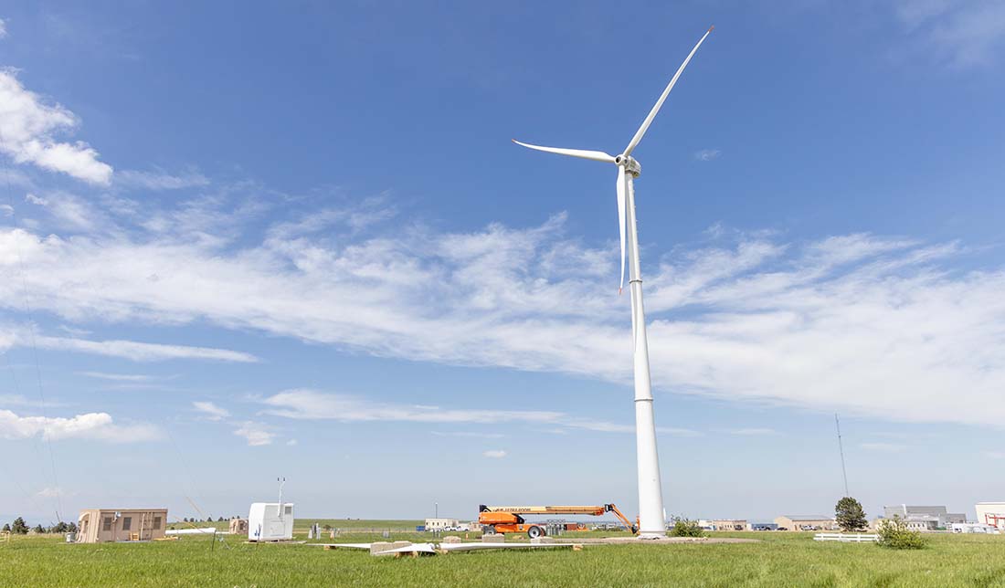 dswind-eocycle-xant-m-26-89865 A small wind turbine next to a crane, small building, and equipment.